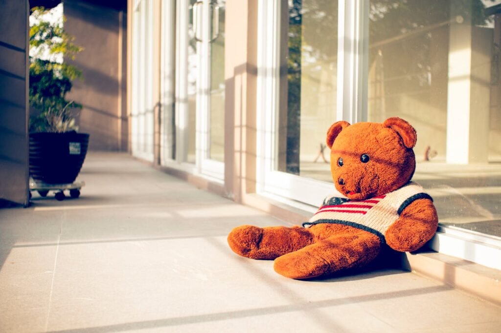 Toy bear in sweater with American flag ornament in town