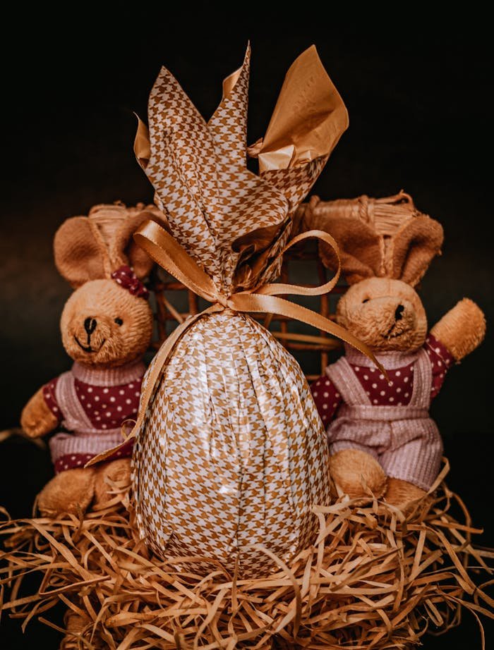 Wrapped chocolate Easter egg composed with toy rabbits